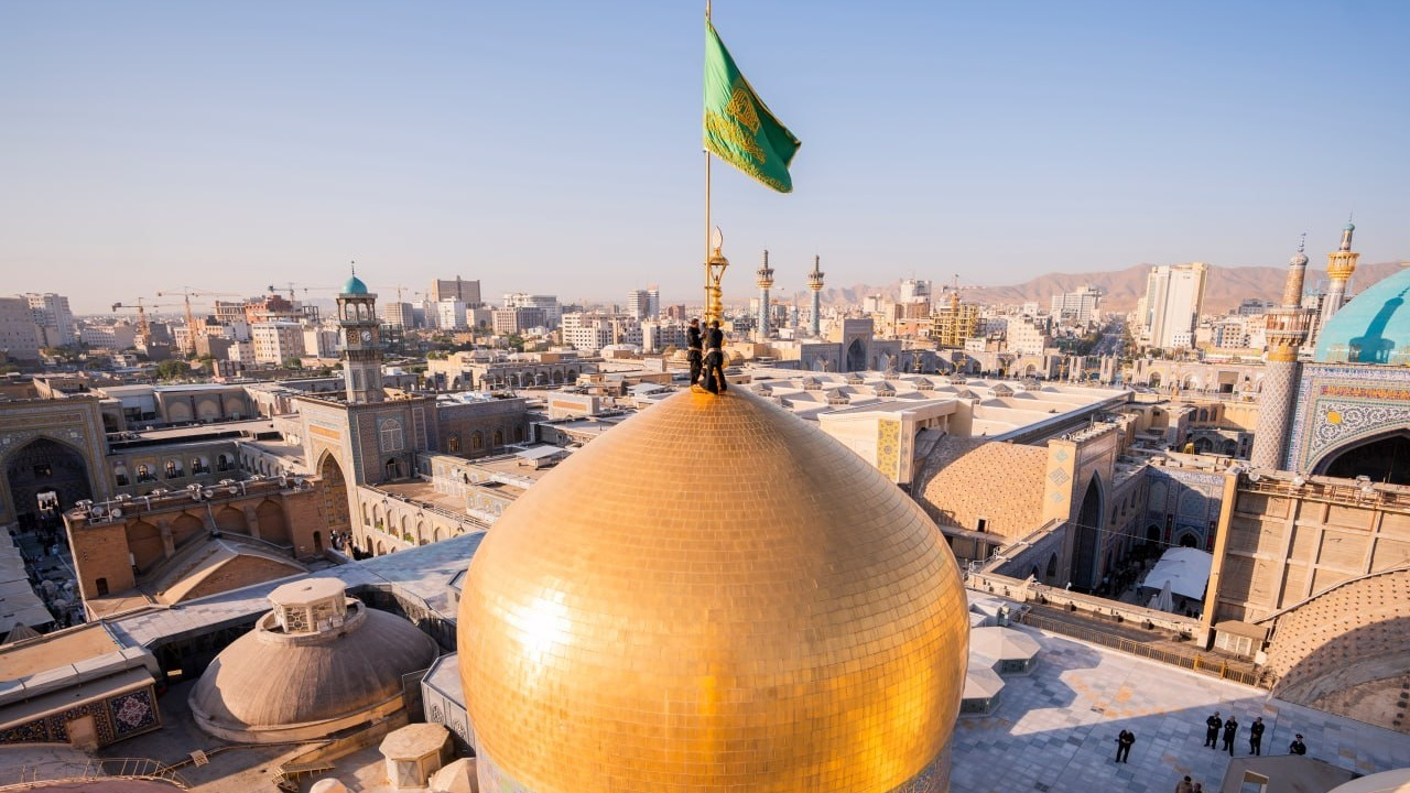 تعویض پرچم گنبد حرم امام رضا (ع) بعد از ۶٣ روز + فیلم